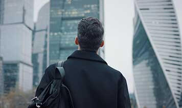 man looking up at buildings