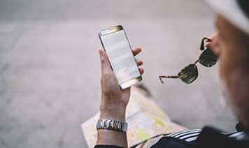 man with sunglasses checking phone