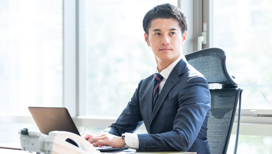 パソコン作業をするスーツを着た日本人男性